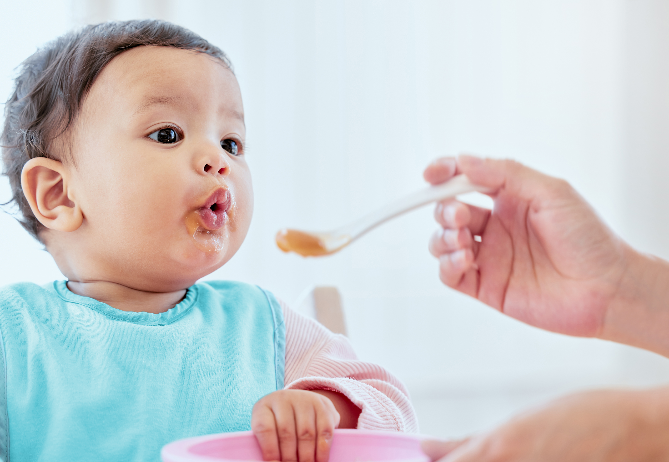 Baby food. A parent feeds an infant pureed baby food.